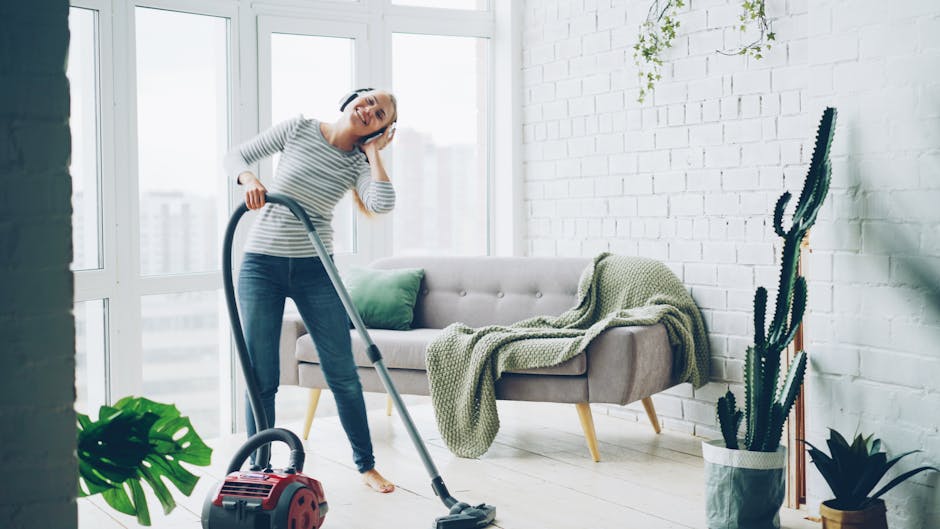 Happy woman listening to music while vacuuming a stylish living room.